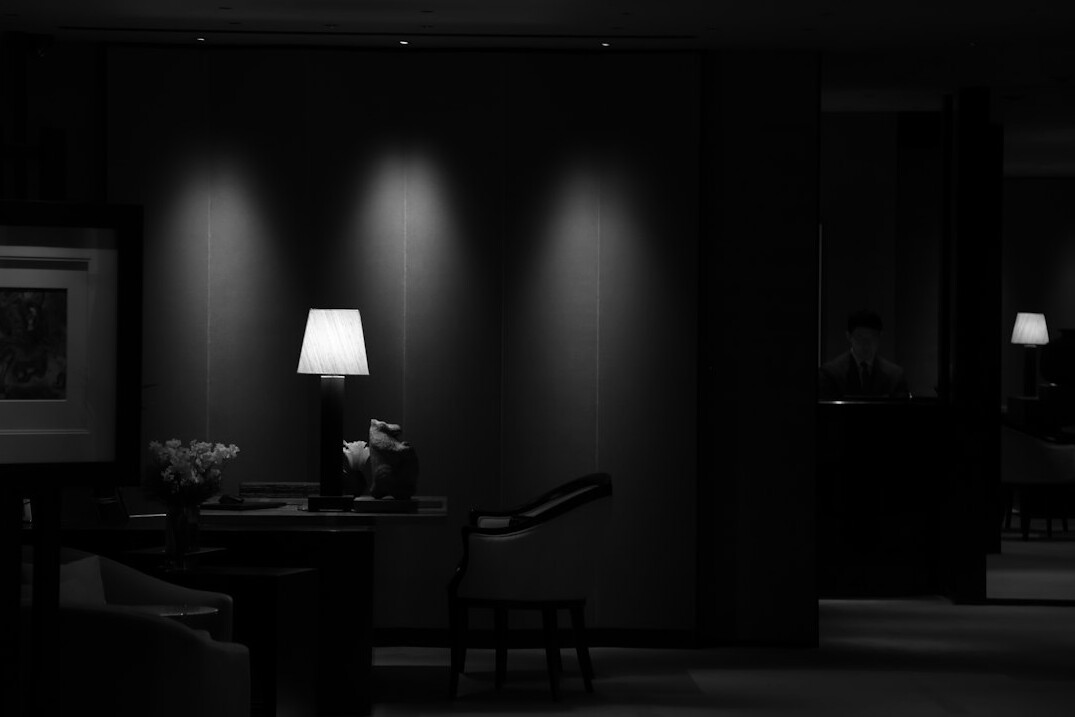 Journalist reviewing documents at a desk under dim light